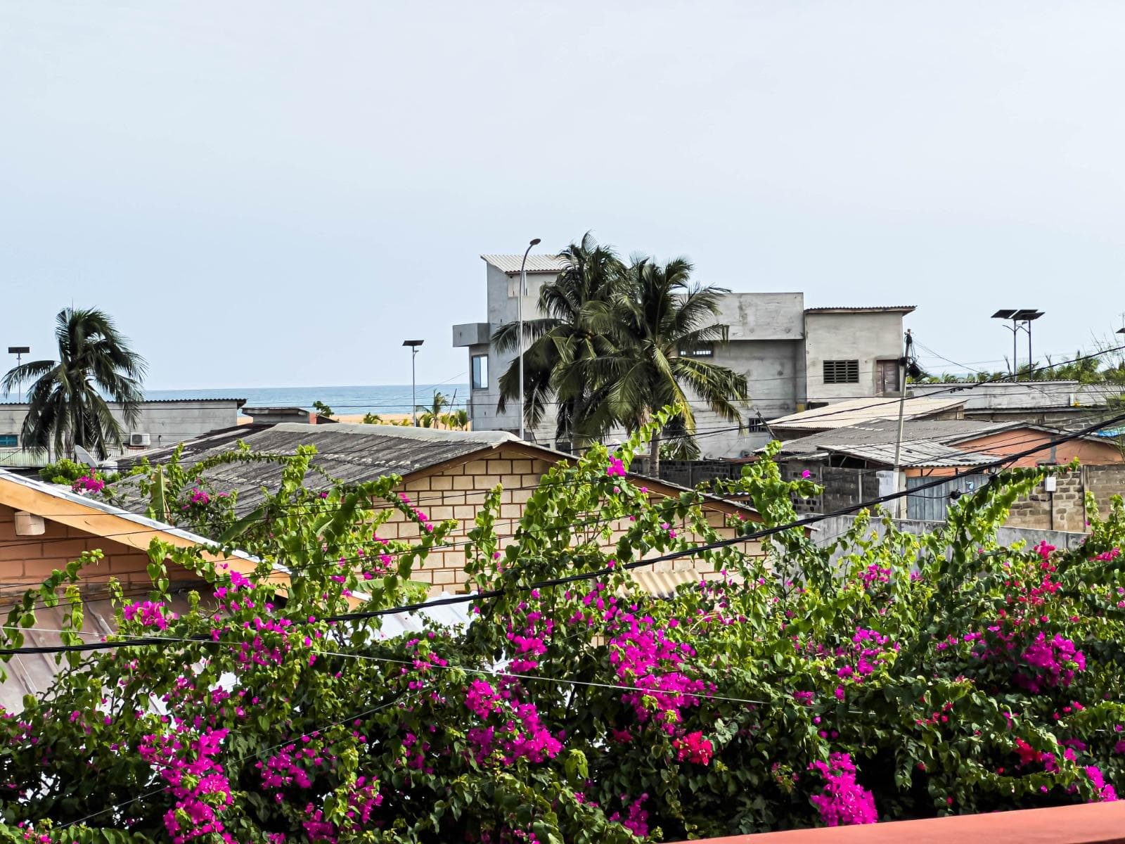 Vue depuis la terrasse : toits de Cotonou et océan